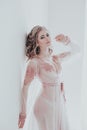 Pretty girl in pink lingerie stands at white walls bride Royalty Free Stock Photo