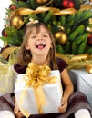 Pretty girl with present near the Cristmas tree