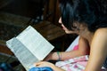 A pretty girl is reading a book on her bed. Close up view.