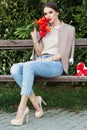 Pretty girl with red tulips sitting on the bench Royalty Free Stock Photo