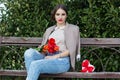 Pretty girl with red tulips sitting on the bench Royalty Free Stock Photo