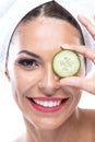 Pretty girl reducing swelling and soothing damaged skin with a cucumber slice