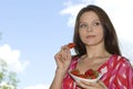 Pretty girl relaxing on balcony and eat red fresh Royalty Free Stock Photo