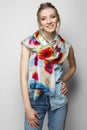 Pretty girl in jeans and colorful silk scarf posing on white background