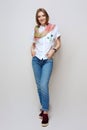 Pretty girl in rolled up jeans, gumshoes and silk scarf posing on white background