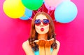 Pretty girl sends an air kiss holds an air colorful balloons Royalty Free Stock Photo