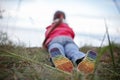 Pretty girl in shoes with rainbow color bottom sitting on the bank of sea, girls power and tolerance