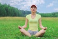 Pretty girl in short shorts and a yellow t-shirt meditatin