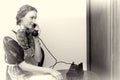 Pretty girl sitting and speaking via old phone Royalty Free Stock Photo