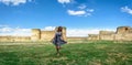 A pretty girl in a skirt on the background of panoramas of the fortress