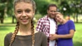 Pretty girl smiling on background of her happy parents, loving and caring family Royalty Free Stock Photo