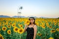 Pretty girl standing in background of sunflower field during sunset light. Royalty Free Stock Photo