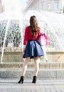Pretty girl is standing in front of a fountain. Royalty Free Stock Photo