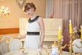 Pretty girl stands next to classic white table