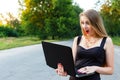 Pretty girl stares at laptop while on the road