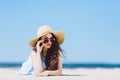 Pretty girl in straw hat laying on the sandy beach Royalty Free Stock Photo