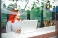 Pretty girl student study with personal laptop computer near window. A young women entreprenuer enthusiam about the future