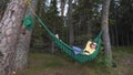 Pretty girl in sunglasses relaxing in a hammock in the forest