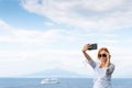 Pretty girl in sunglasses Takes a selfie photo. Sea and horizon in the background. Vacation and travel concept. Communication on a Royalty Free Stock Photo