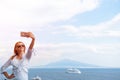 Pretty girl Takes a selfie photo. Sea and horizon in the background. Vacation and travel concept. Communication on a mobile Royalty Free Stock Photo