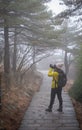 The pretty girl taking photo with icy frost on the leaf on the pine tree at the Huangshan mountain