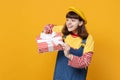 Pretty girl teenager in french beret, denim sundress looking aside, holding red striped present box with gift ribbon Royalty Free Stock Photo