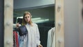 A pretty girl tries on handbags to her style of clothing. Shopping