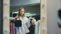 A pretty girl tries on handbags to her style of clothing. Shopping