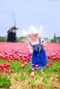 Pretty Girl In Tulips Field With Windmill In Dutch Costume