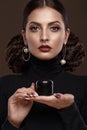 Pretty girl, unusual hairstyle, bright makeup, red lips and manicure design with a jar of nail polish in her hands Royalty Free Stock Photo