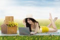 Pretty girl uses laptop while lying at field Royalty Free Stock Photo