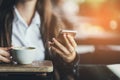 Pretty Girl Using Cell Phone Smiles.In cafe.With coffee Royalty Free Stock Photo