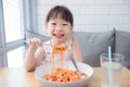 Pretty girl using fork eating spaghetti by herself Royalty Free Stock Photo