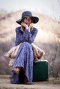 Pretty girl with vintage case on a dirtroad