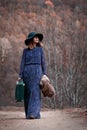 Pretty girl with vintage case on a dirtroad