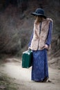 Pretty girl with vintage case on a dirtroad