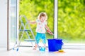 Pretty girl washing a window in white room Royalty Free Stock Photo