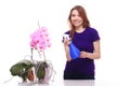 Pretty girl watering orchid flower with spray