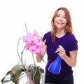 Pretty girl watering orchid flower with spray