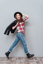 Pretty girl wearing leather jacket over her shoulder and walking Royalty Free Stock Photo