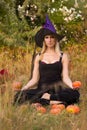 Pretty girl in witch costume training lotus pose