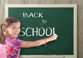 Pretty girl writting back to school on blackboard Royalty Free Stock Photo