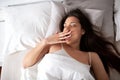 Pretty girl yawning on her warm bed Royalty Free Stock Photo