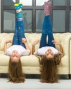 Two funny girls are lying in the studio on the couch upside down Royalty Free Stock Photo