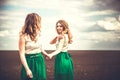 Pretty girls outdoor walking in the field, holding hands Royalty Free Stock Photo