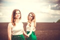 Pretty girls outdoor walking in the field, holding hands Royalty Free Stock Photo