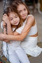 pretty girls in white clothes rides on swing. children& x27;s friendship.