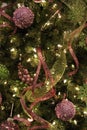 Pretty gold and pink sparkling holiday ribbons and handmade decorations adorn a Christmas tree