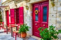 Pretty Greek tavern red front door with sidewalk tables Lefkada Greece Royalty Free Stock Photo