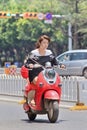 Pretty gril on a red retro style e-bike, Kunming, China